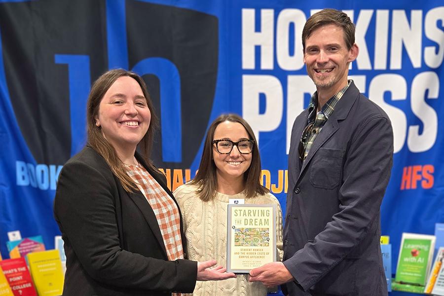 Dr. Sarah Madsen, Cara Cliburn Allen, and Nathan Alleman holding their book, titled Starving the Dream